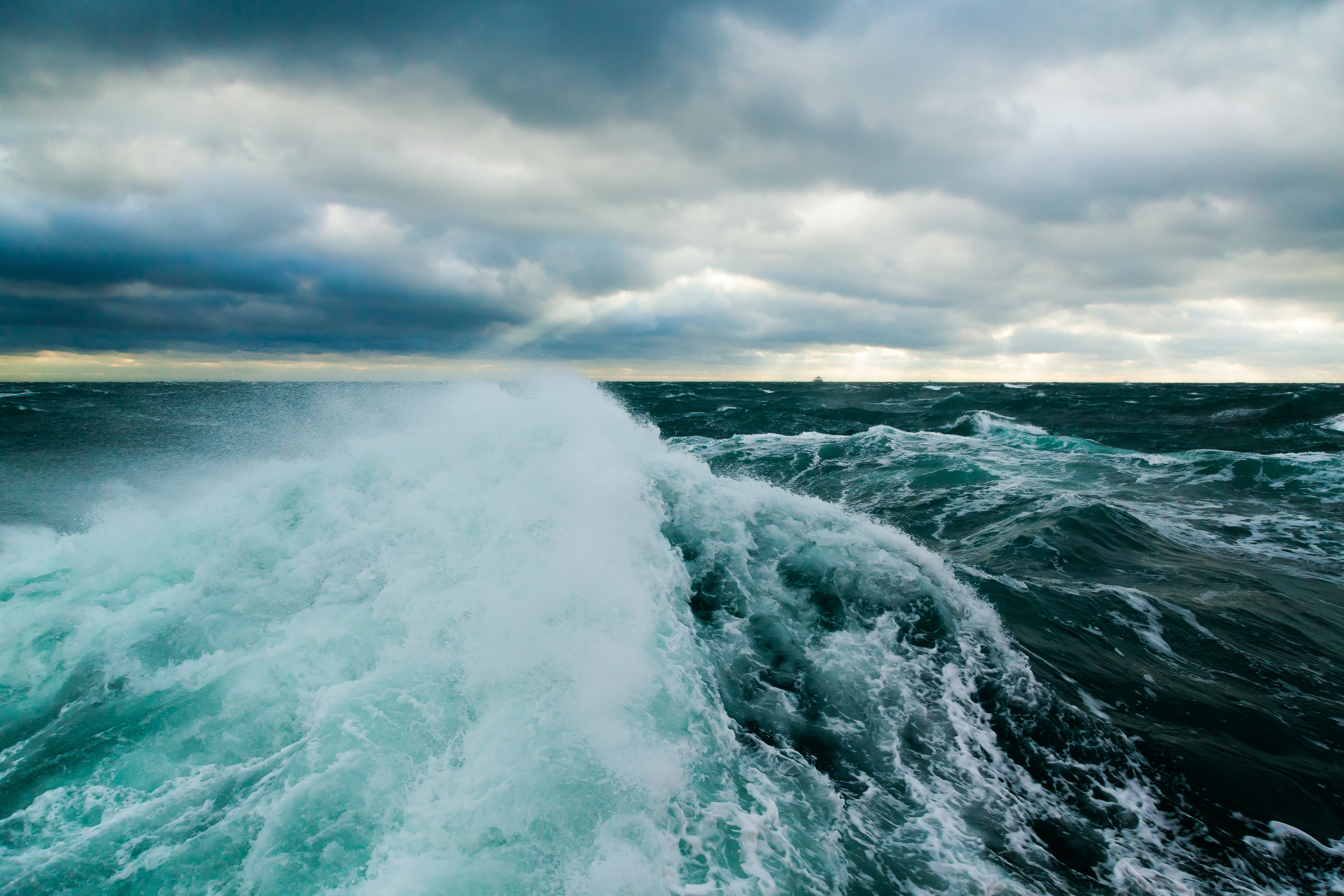 picture of an ocean wave under a cloudy sky