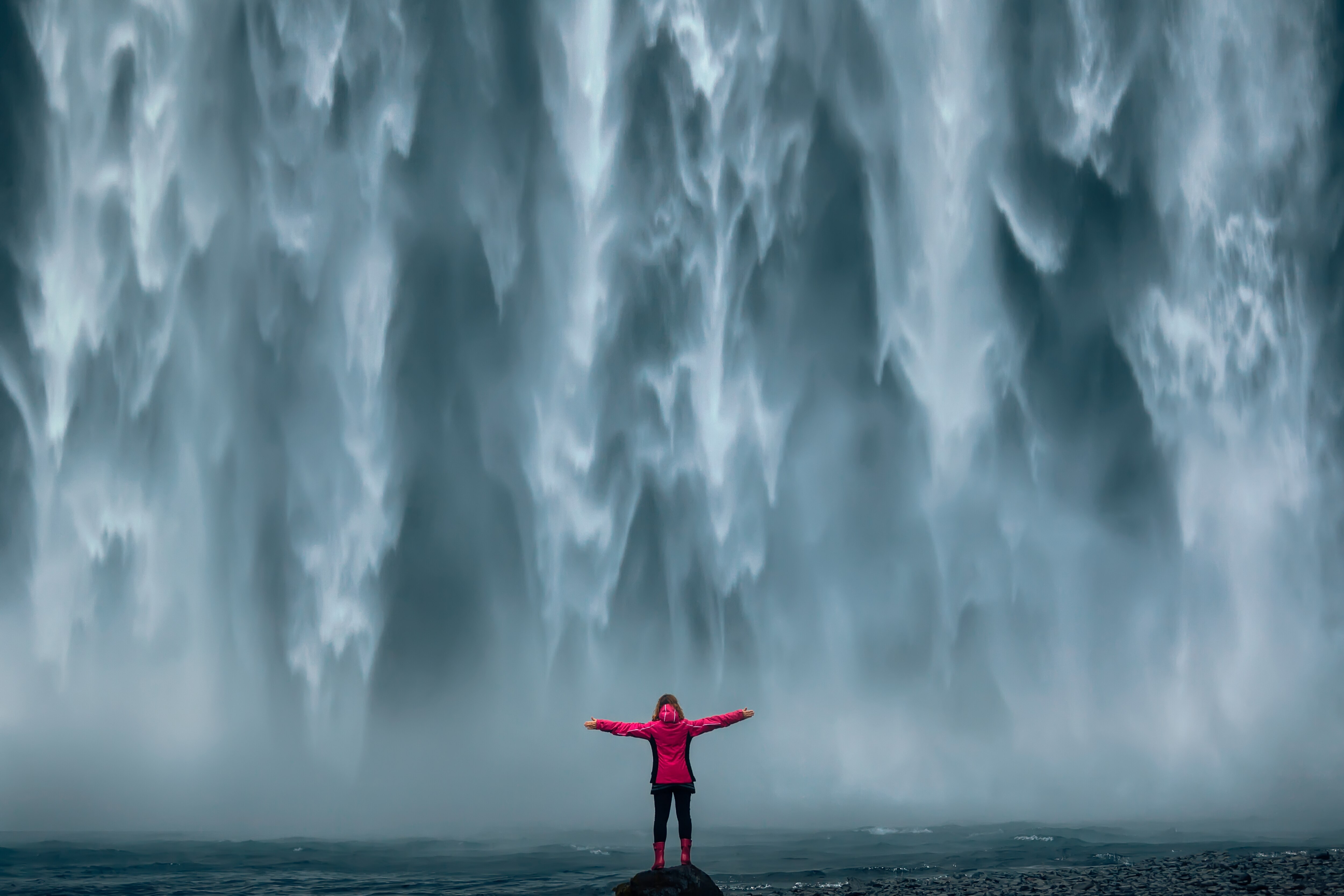Person standing in front of waterfall