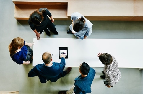 a group of people standing around a table