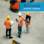 Schwab Market Update:  Workers in orange jackets in a factory.