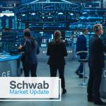 Schwab Market Update: Stock exchange trader work together in an office, surrounded by screens and large charts. 