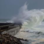Large wave crashing on rocky shore