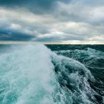 picture of an ocean wave under a cloudy sky