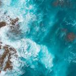 top view of waves crashing on rocks