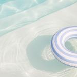 blue and white striped pool tube floating in a pool